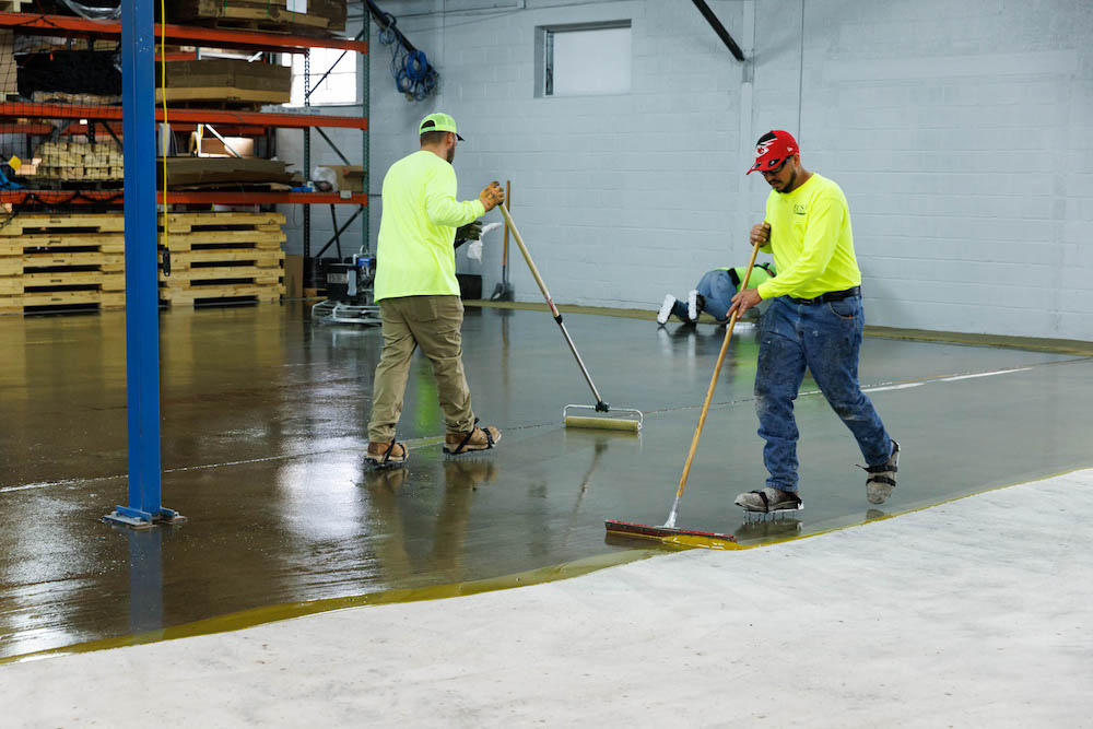 ECS professionals laying down a smooth epoxy coat as part of heavy duty epoxy floor coating in kansas city