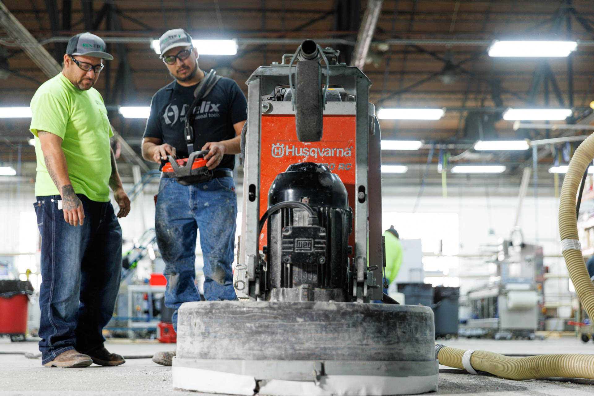 Epoxy Coating Specialists technicians using a machine to help improve the floor as they put down a quick curing resinous floor