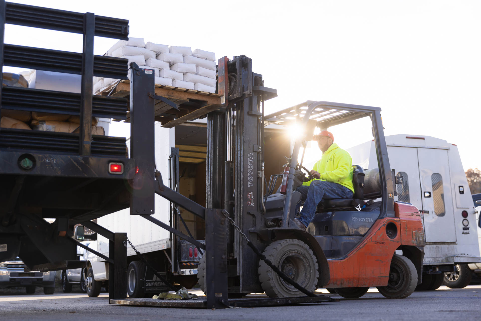 A forklift loading epoxy floor materials into a truck which is part of epoxy floor cost