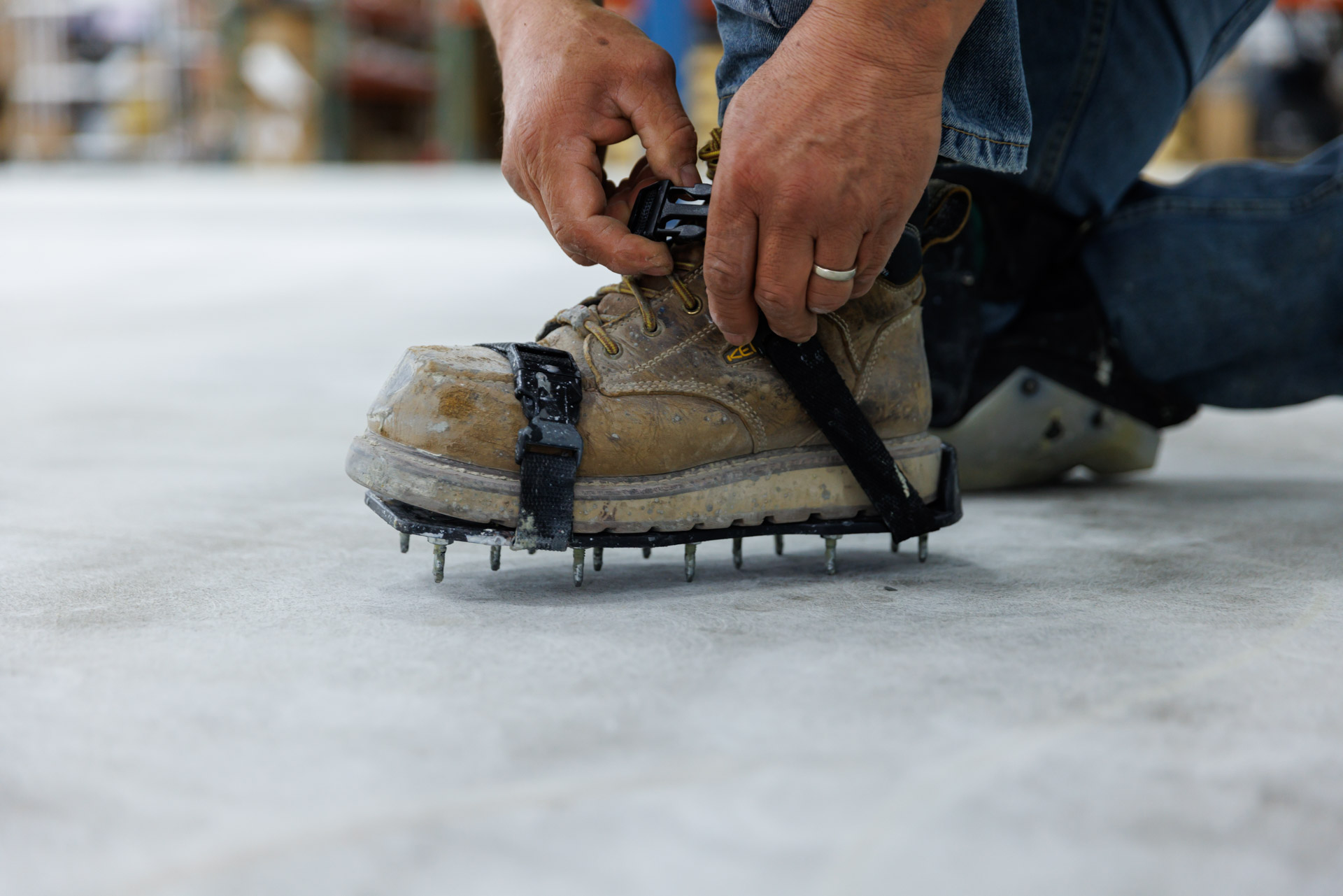 hands securing job-specific shoe attachments on job site for concrete overlay in kansas city